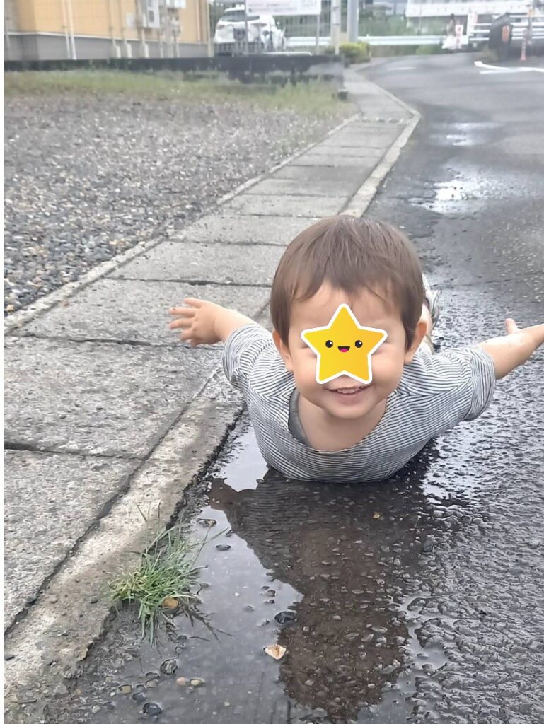 雨上がり散歩中に水溜まりで遊ぶ子供