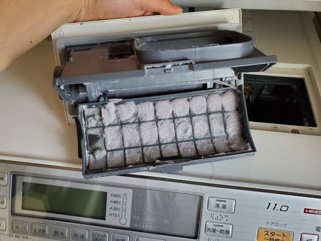 洗濯機（パナソニック）の乾燥フィルターを取り出した所。ほこりが多くついている。