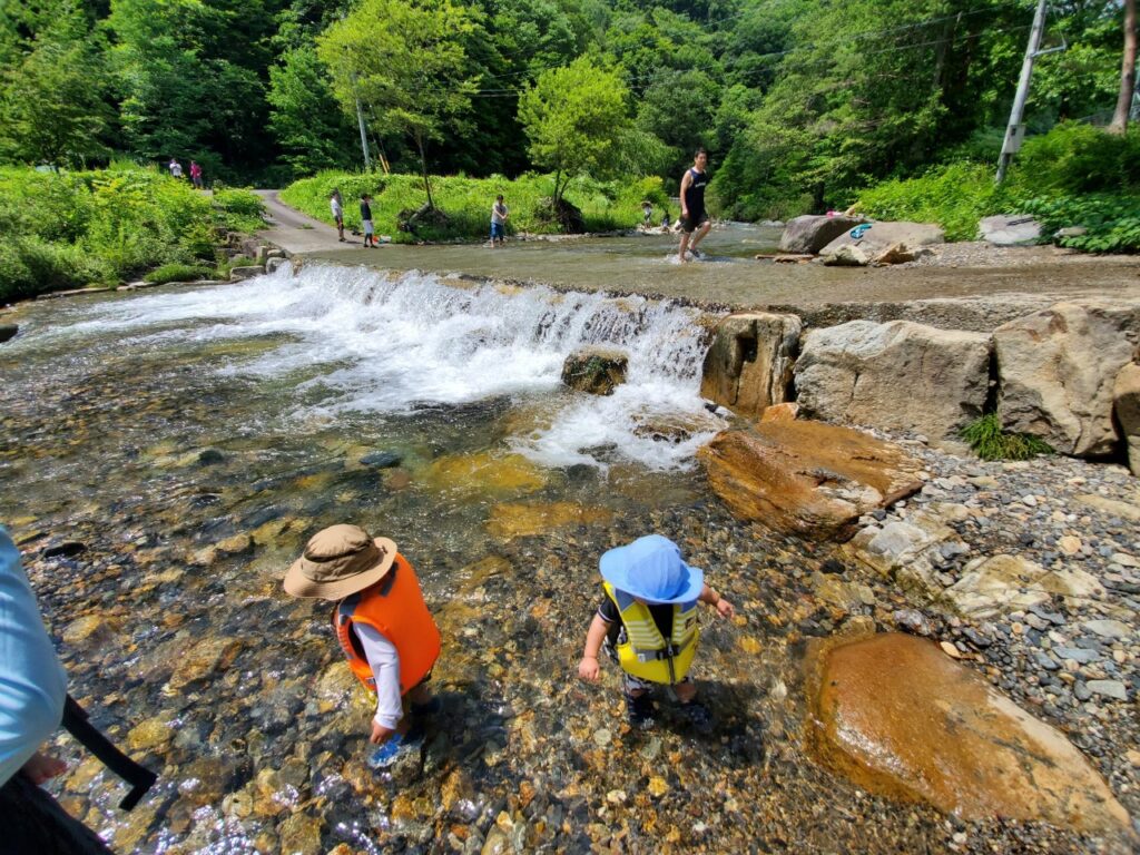 カクレハ高原キャンプ場の川下流で遊ぶ子供